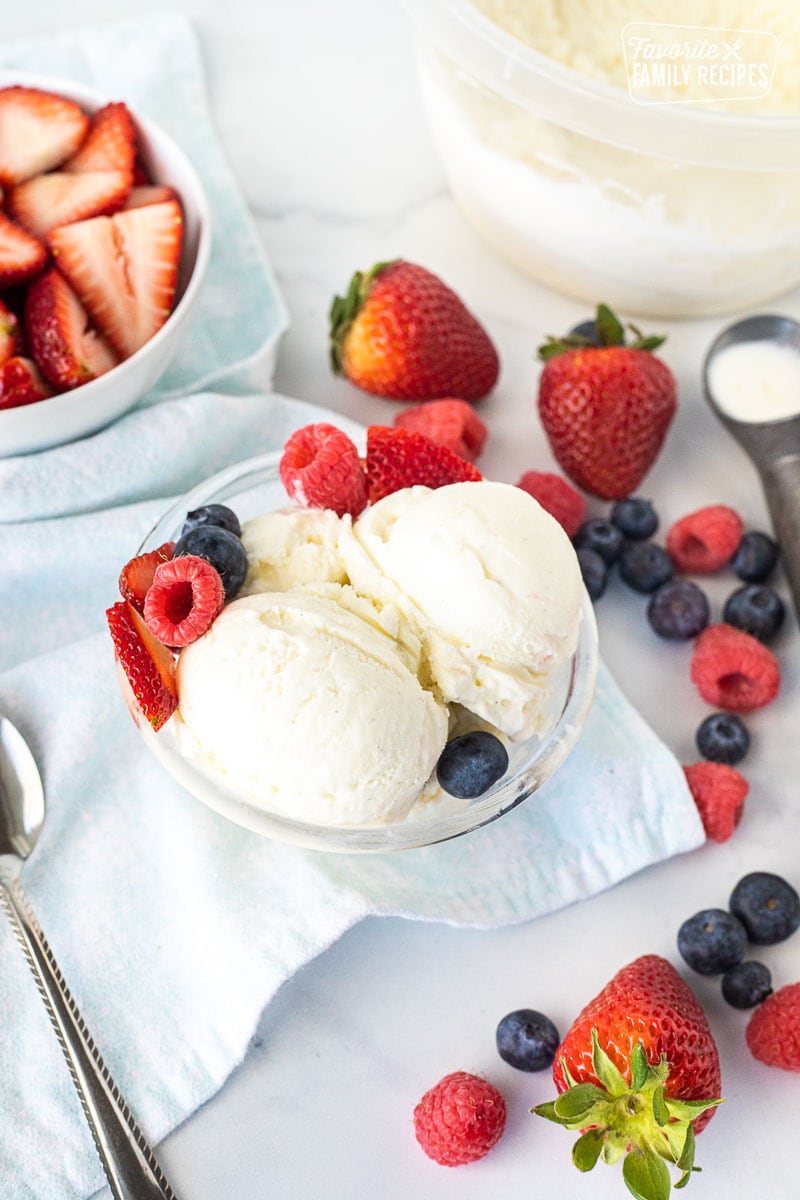 Scooped Homemade Vanilla Ice Cream with fresh berries in a bowl.