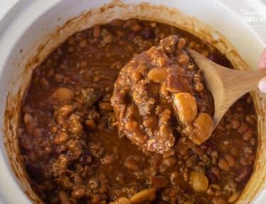 Spoon holding up cooked Baked Beans.