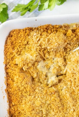Spoon resting in a casserole dish of Poppy Seed Chicken.