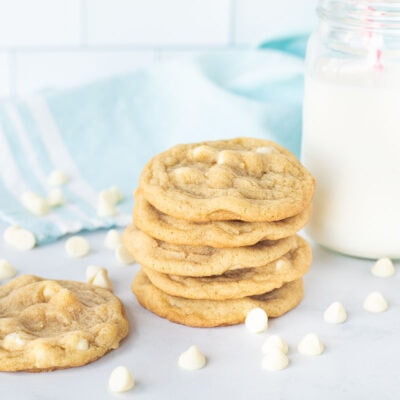 Stack of Vanilla Cookies with a tall glass of milk and vanilla chips.