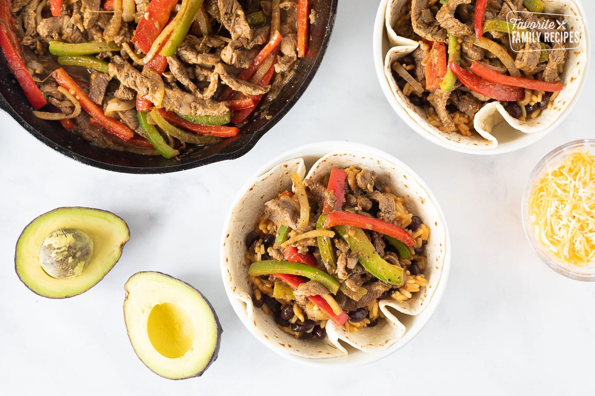 Steak mixture added on top of rice and bean mixture for Steak Fajita Bowls.