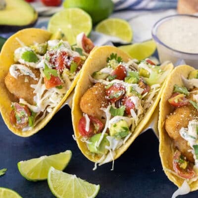 Three Easy Fish Tacos on corn tortillas with pico de Gallo, cilantro cream sauce and cotija cheese.