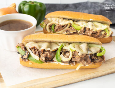 Two full Philly Cheesesteaks with melted provolone cheese.