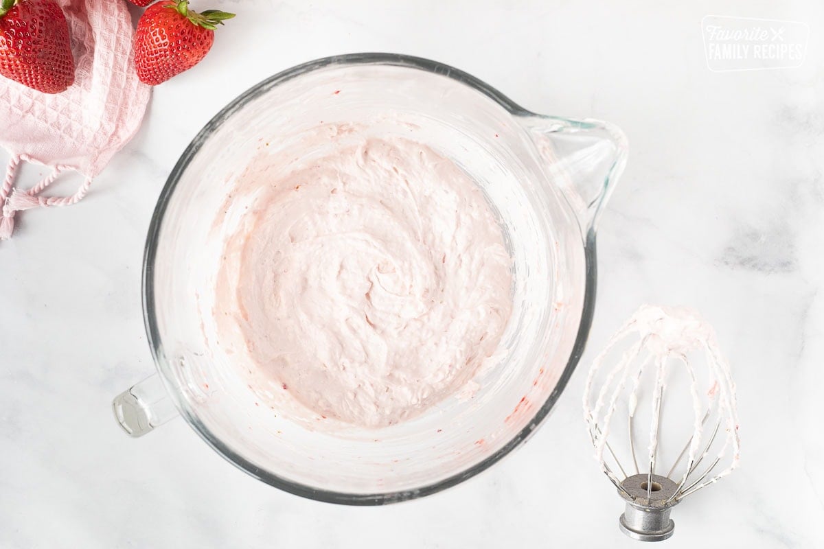 Mixing bowl with cram cheese and blended strawberries for Fresh Strawberry Cake.