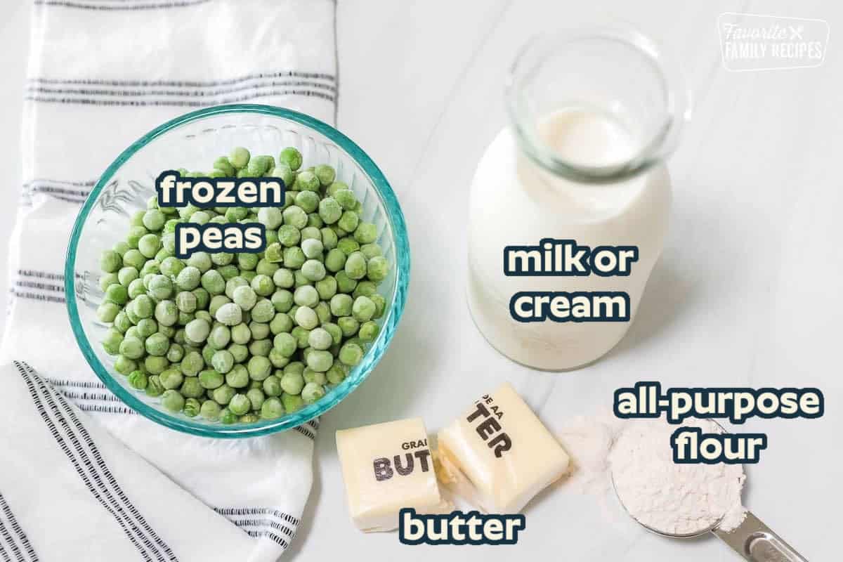 Frozen peas in a glass bowl next to butter, milk, and flour.