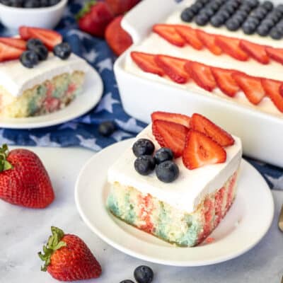 4th of July Cake with red and blue Jello topped with frosting, strawberries and blueberries.