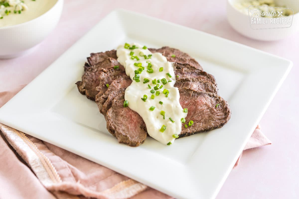 A plate of steak topped with blue cheese sauce