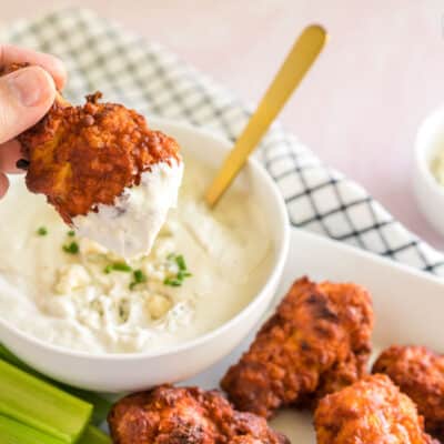 A buffalo wing dipped in blue cheese sauce