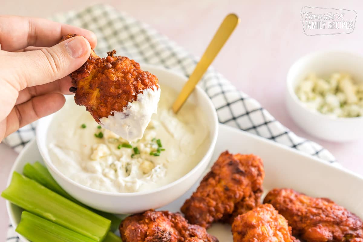 A buffalo wing dipped in a white sauce