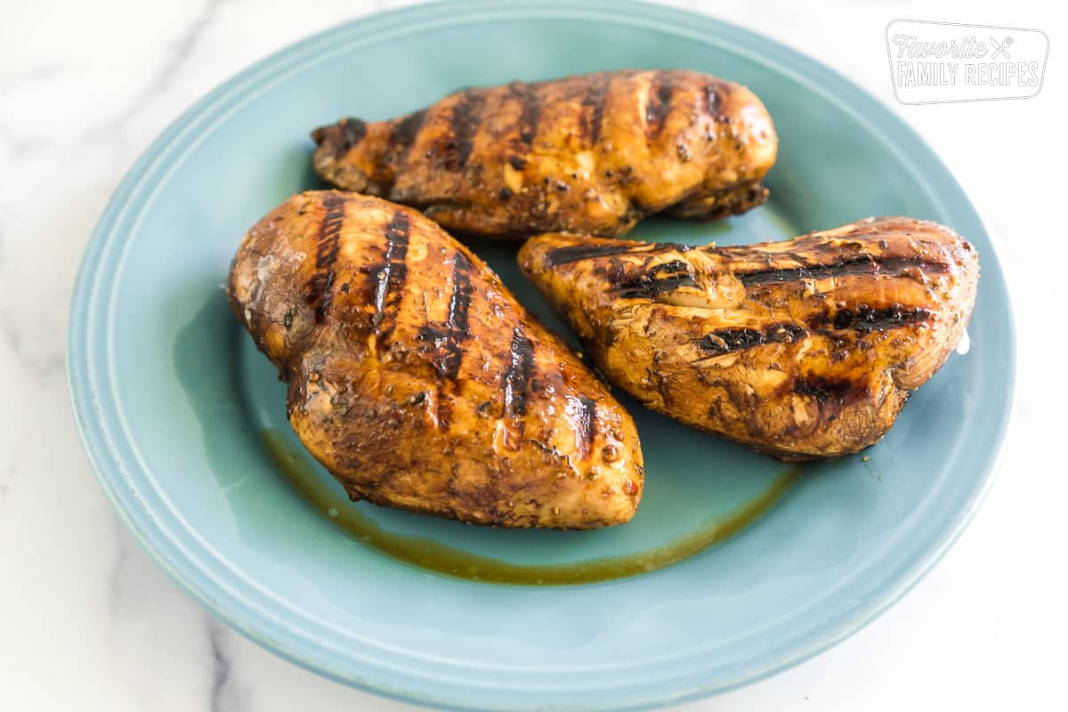 three grilled chicken breasts on a blue plate