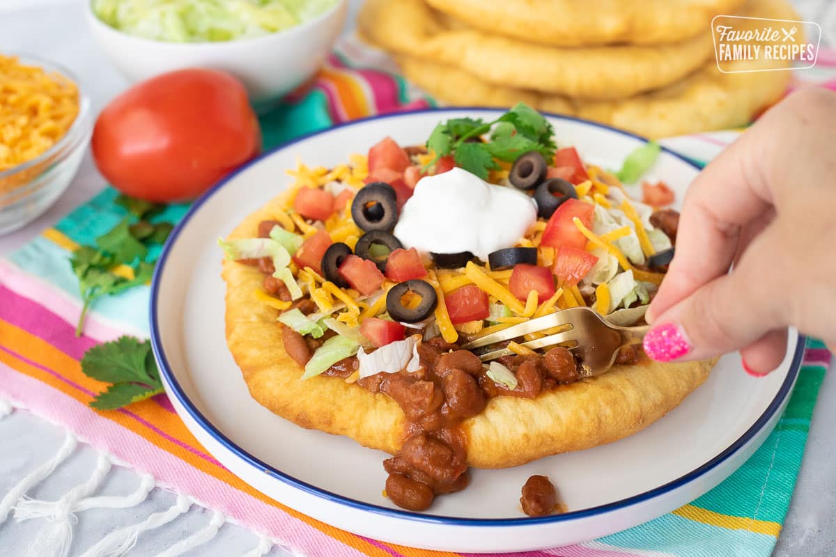 Cutting into a Navajo Taco with a fork.