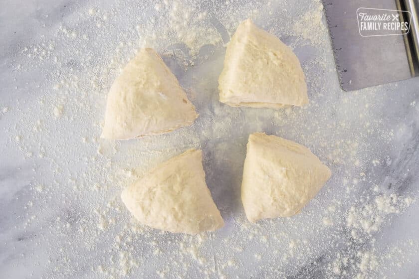 Dough cut into four equal sections on a floured surface to make Fry Bread.