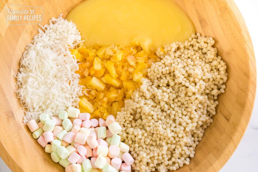 Pineapple curd, coconut, couscous, fruit, and marshmallows in a bowl