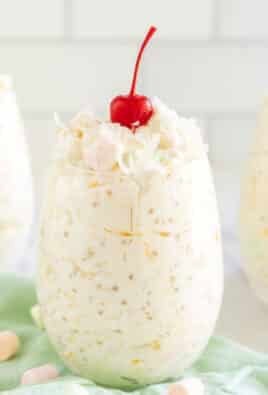 Frog eye salad in little cups topped with maraschino cherries