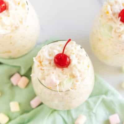Frog eye salad in little cups topped with maraschino cherries