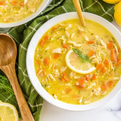 A bowl of Greek Lemon Chicken Soup topped with a lemon slice and fresh dill