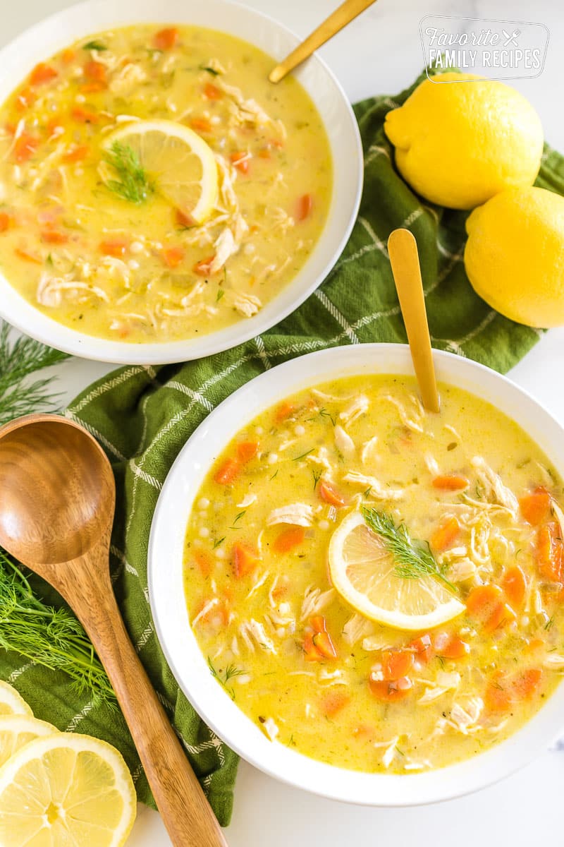Two bowls of Greek Lemon Chicken Soup topped with lemon slices and fresh dill.