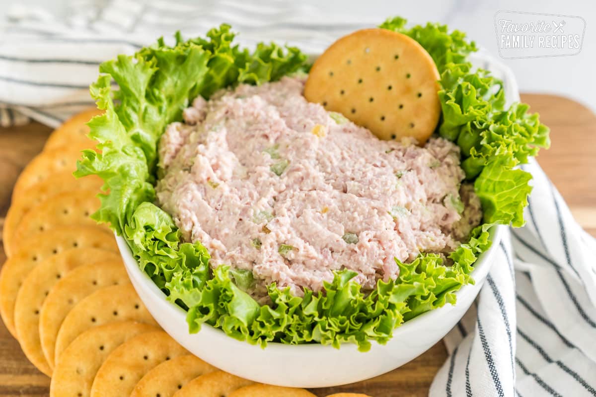 Ham salad in a bowl with lettuce and crackers.
