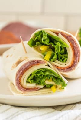 An italian sandwich wrap cut in half and stacked on top of each other