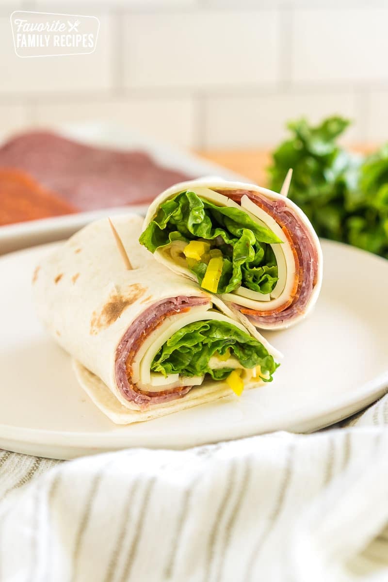 An italian sandwich wrap cut in half and stacked on top of each other