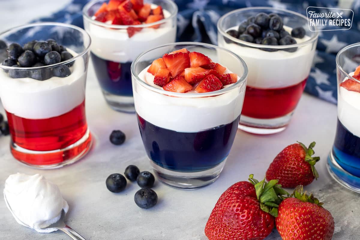 Red and Blue Jello cups topped with whipped topping and fresh fruit from extra Jello used to make 4th of July Cake.