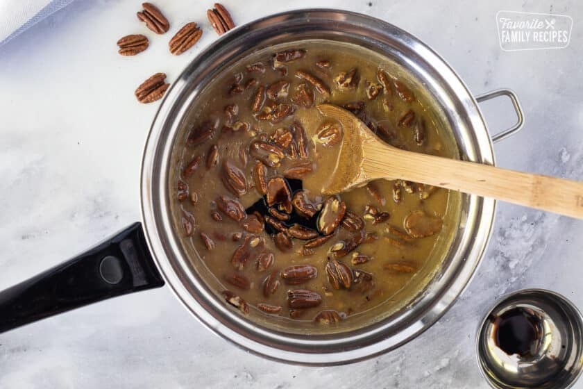 Adding Mapliene flavoring to pan of Pecan Pralines.