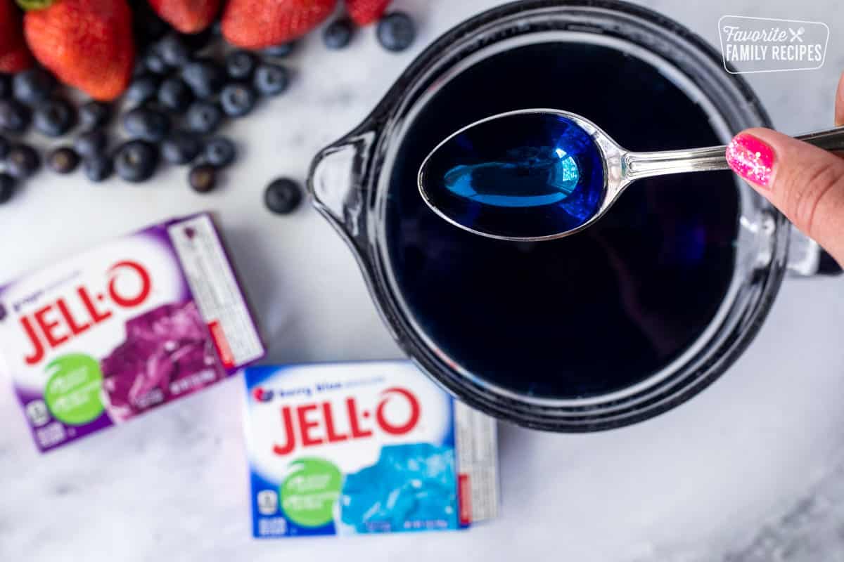 Mixing grape and berry blue Jello in a bowl for 4th of July Cake.