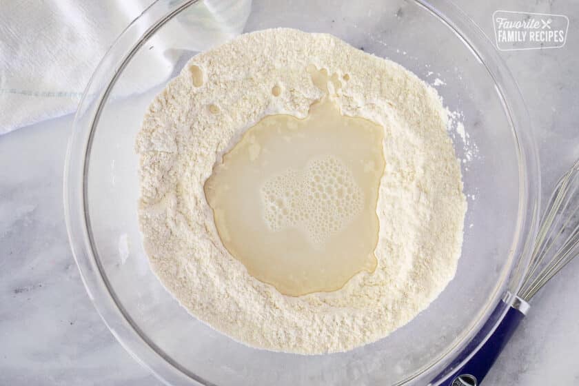 Mixing bowl with dry ingredients and water in the center to mix dough for Fry Bread.