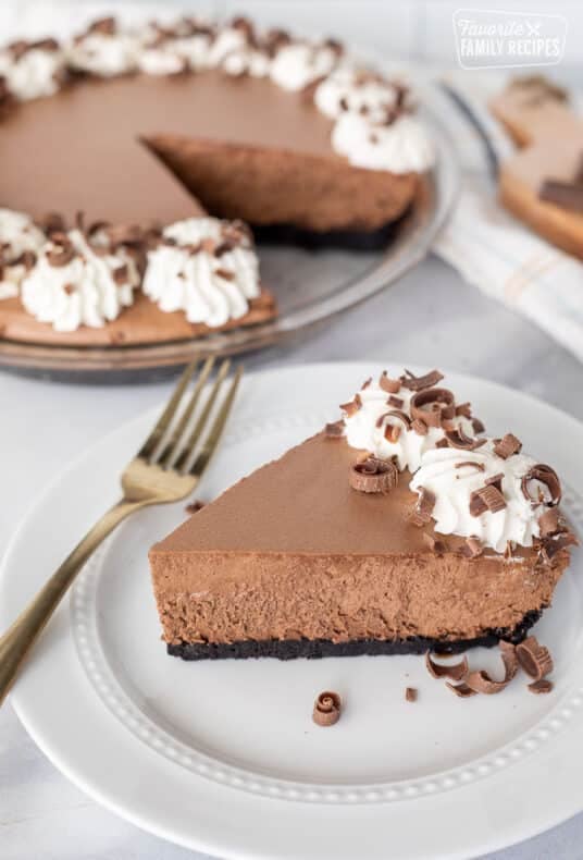 Slice of Chocolate Satin Pie on a plate with extra chocolate curls on the side.