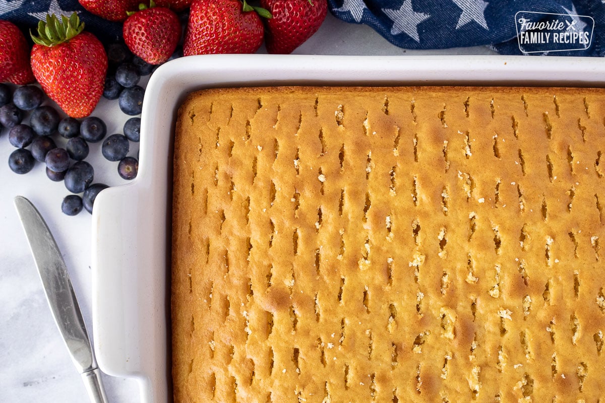 Holes in a baked cake for 4th of July Cake. Butter knife on the side.