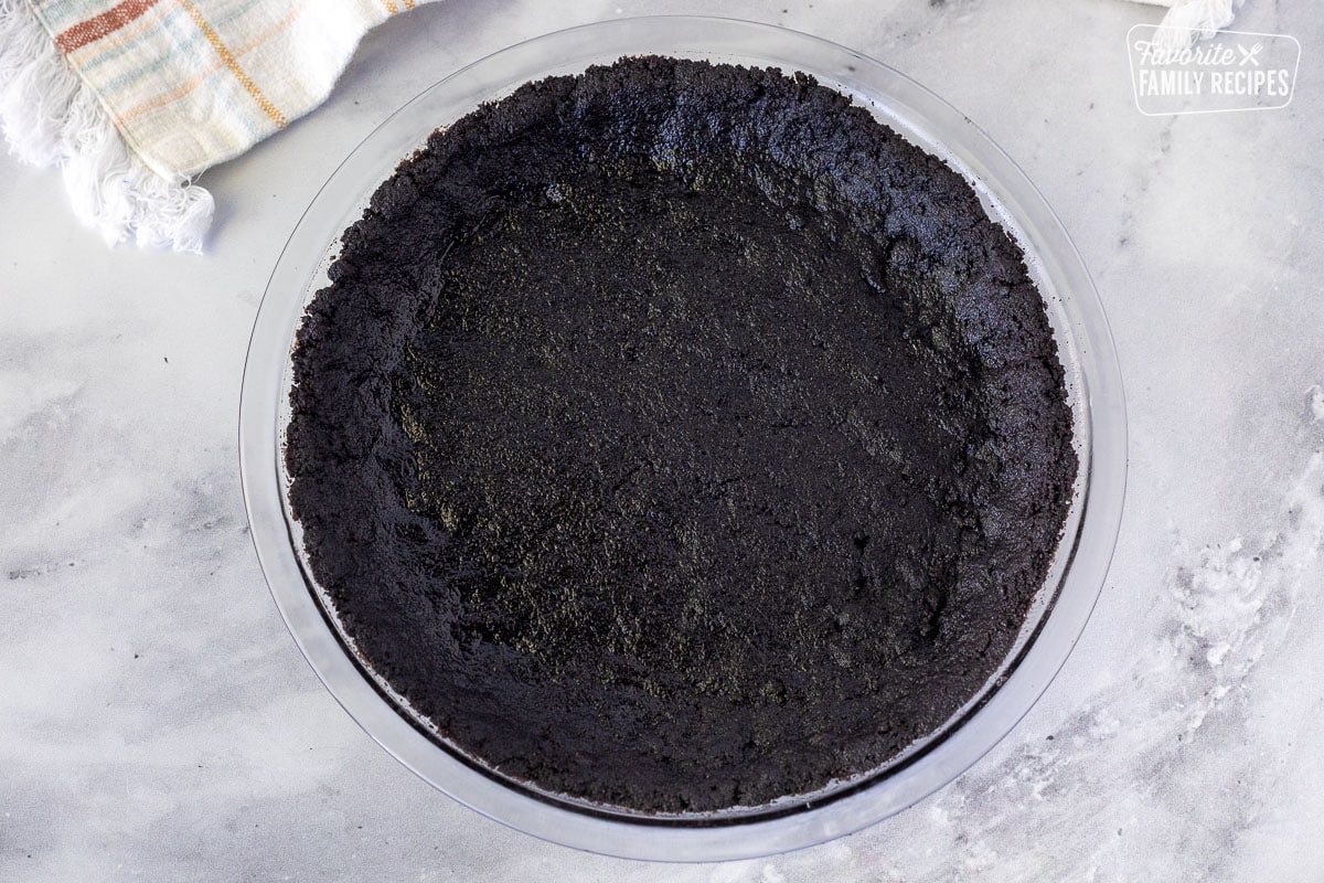 Pressed Oreo crust mixture in a glass pie dish for Chocolate Satin Pie.