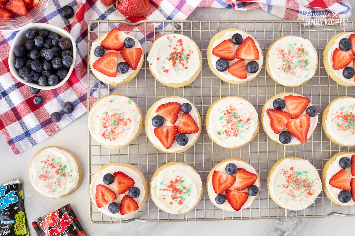 Cooling rack with decorated 4th of July Cookies with Pop Rocks and fresh fruit.