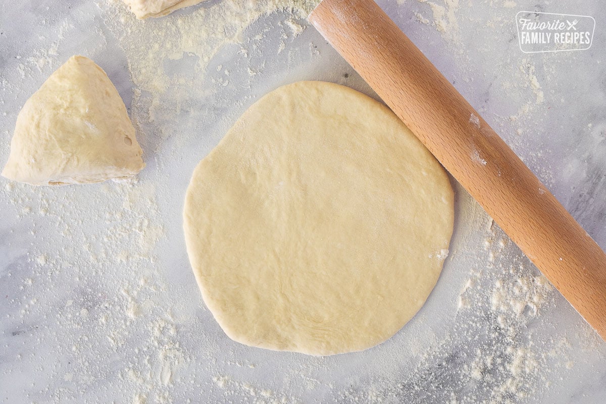 Rolling out a round circle of dough on a floured surface for Fry Bread.