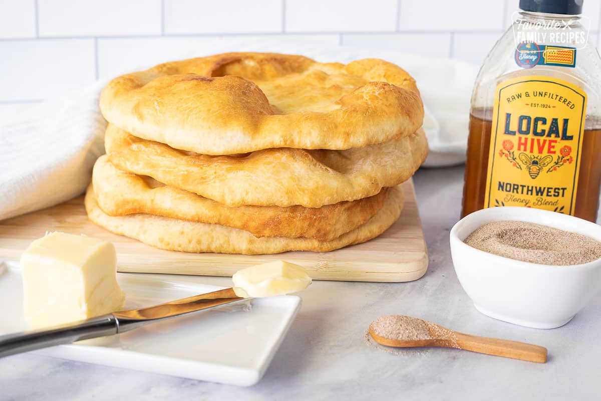 Stack of Fry Bread next to honey, butter and cinnamon sugar mixture.