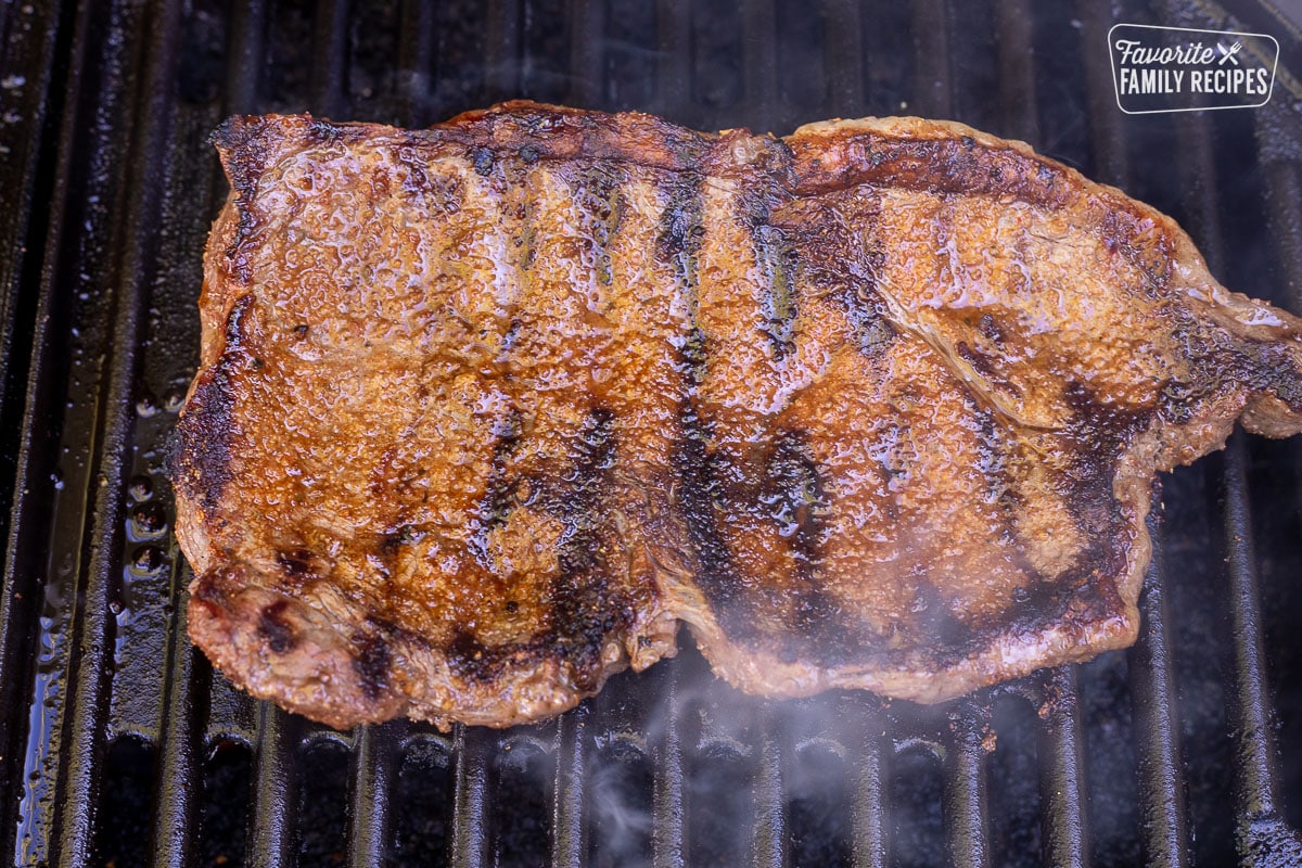Grilling a seasoned steak on the barbecue for Street Tacos.