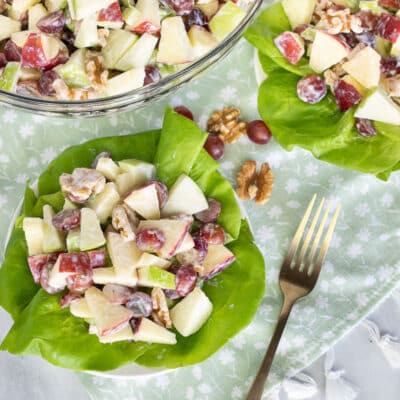 Plates of Waldorf Salad on lettuce with a fork.