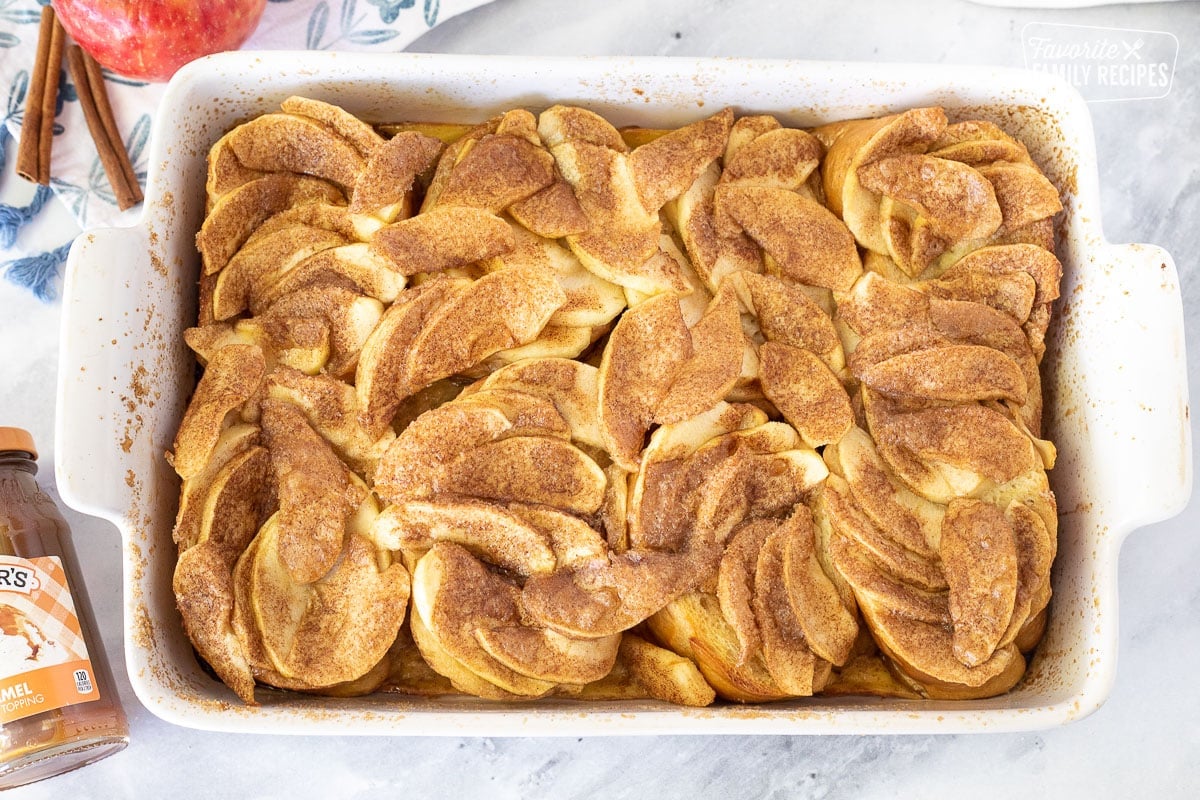 Baked Caramel Apple French Toast Casserole next to caramel sauce.