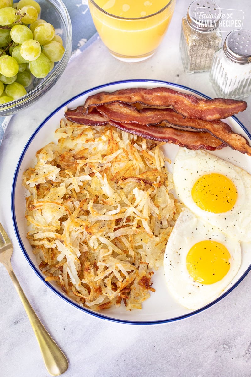 Hash Browns, bacon and eggs on a plate.