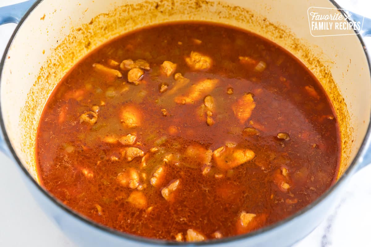 Chicken simmering in broth and spices