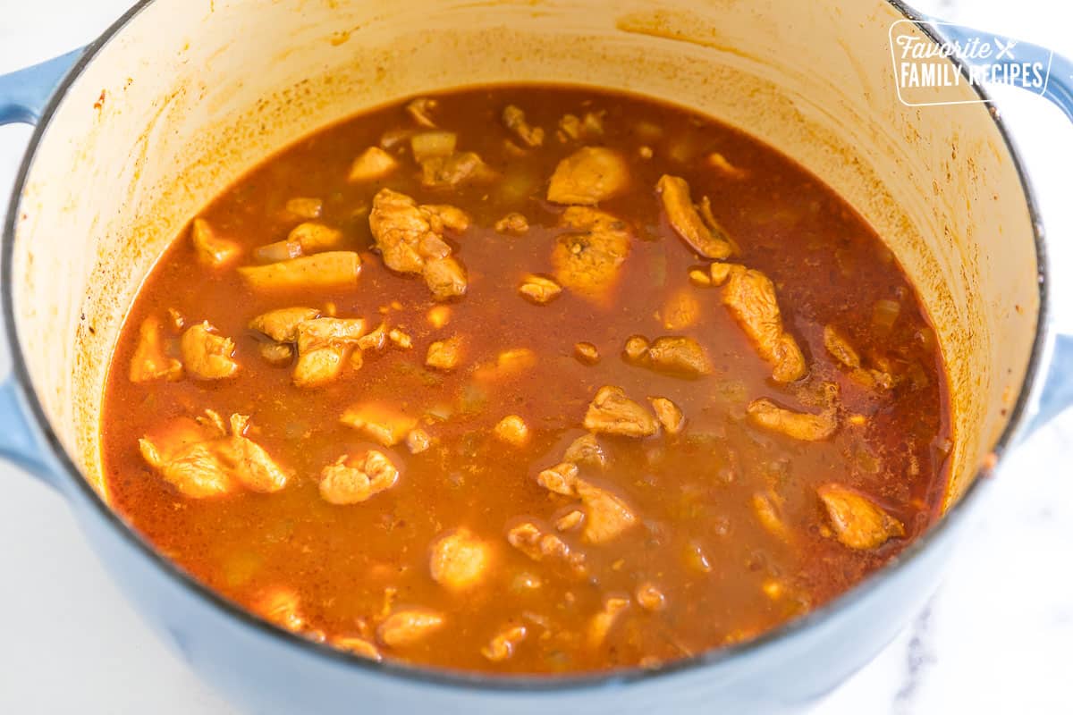 chicken simmering in broth and spices