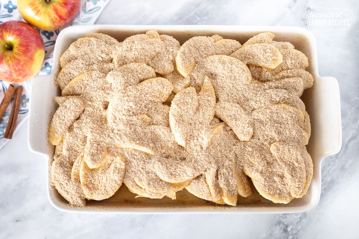 Cinnamon sugar topping covering baking dish of Caramel Apple French Toast Casserole.