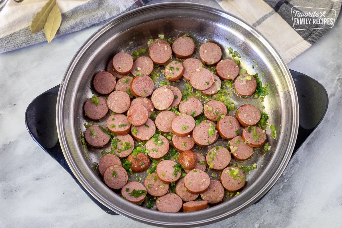 Skillet with cooked smoked sausage, green onion and garlic for Brazilian Rice and Beans.