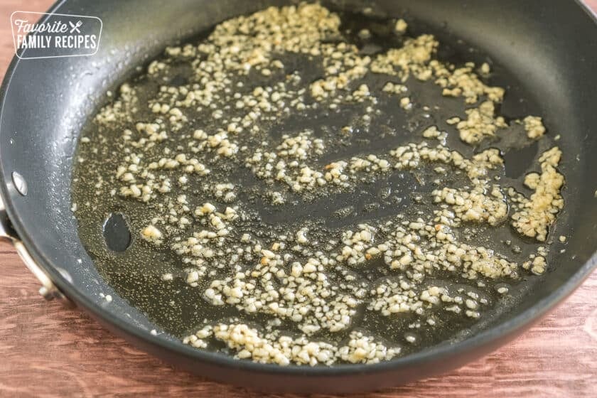 garlic cooking in bacon grease in a pan