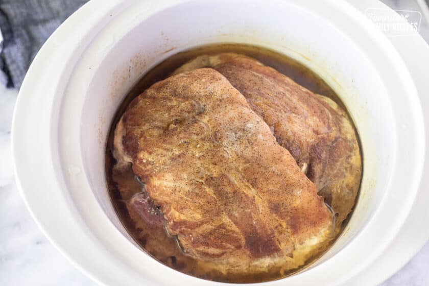 Crock pot with cooked racks of ribs.