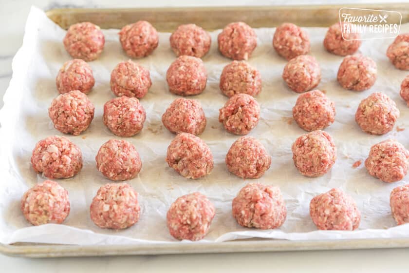 raw meatballs on a baking sheet