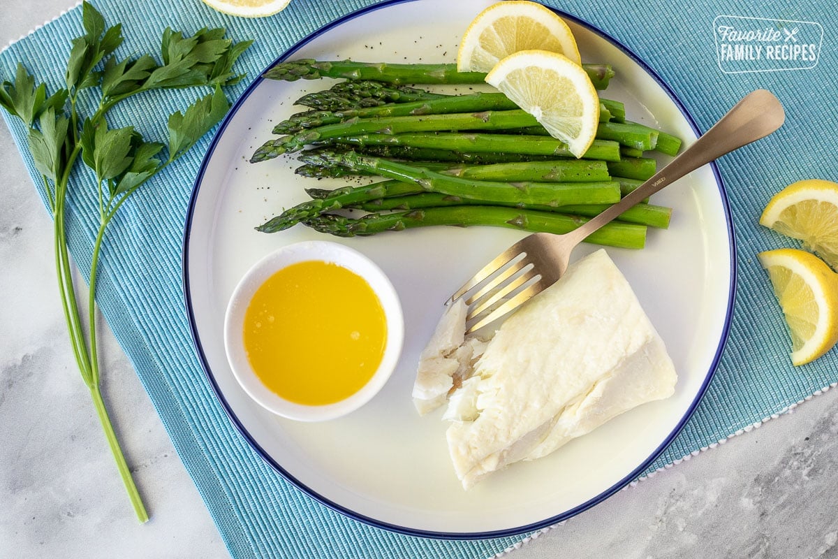 Plate of Poor Man's Lobster, asparagus, dish of melted butter and lemon wedges.