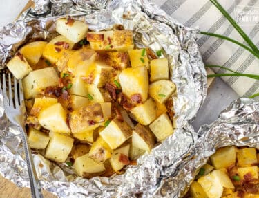 Grilled Ranch Potatoes in Foil topped with bacon, cheese and chives.