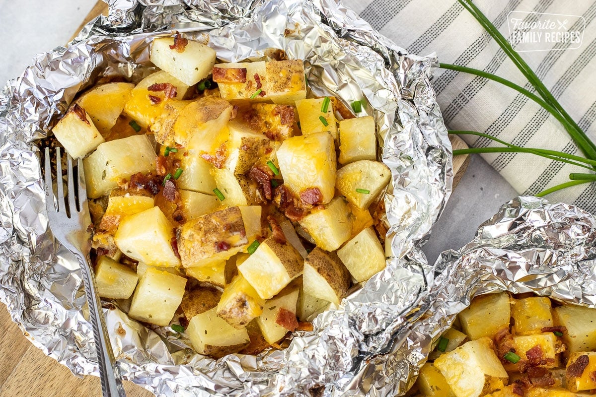 Grilled Ranch Potatoes in Foil topped with bacon, cheese and chives.