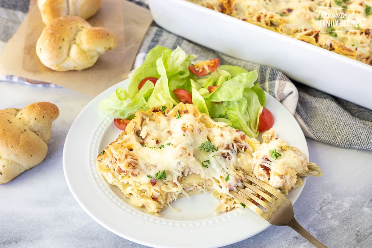 Fork pulling cheesy bite of White Chicken Lasagna.