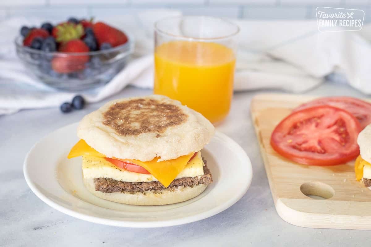 Freezer Breakfast Sandwich with sliced tomato on a plate.